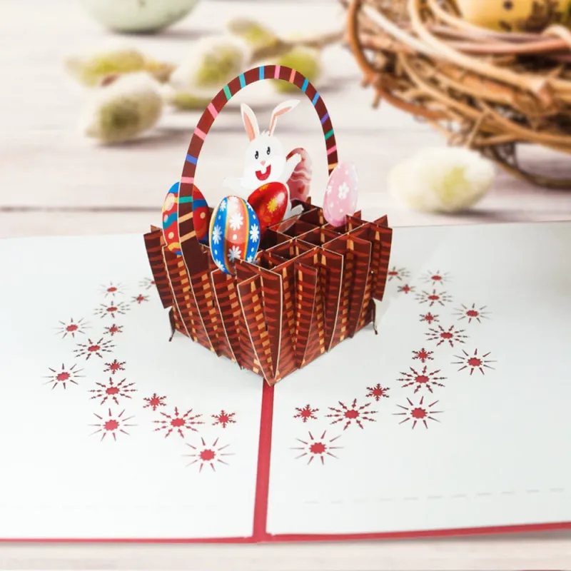 2ca075041e0ce65e5cff56f3f82c8653webp - printshop4me.ae Easter basket 3D pop-up greeting card featuring a woven basket filled with colorful Easter eggs and a smiling bunny. A handcrafted paper pop-up card for Easter celebrations, spring greetings, seasonal gifting, and festive home display.