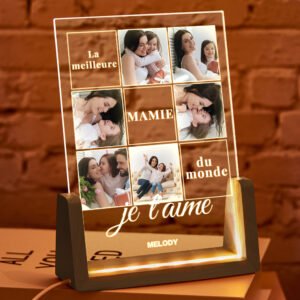 Personalized acrylic LED photo night light featuring a collage of family photos with engraved French text reading "La meilleure MAMIE du monde, je t'aime" and a custom name at the bottom. The illuminated clear acrylic panel sits on a warm LED wooden base, creating a heartfelt keepsake for grandmothers, Mother's Day, birthdays, Christmas, or family celebrations.