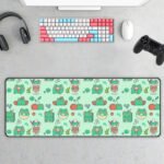 CMP1001jpg - printshop4me.ae Cute kawaii green frog gaming desk mat featuring a seamless pattern of frogs, cherries, matcha drinks, lily pads, flowers, and playful illustrations. Displayed on a modern gaming desk with a pastel mechanical keyboard, mouse, headphones, and game controller, this extended mouse pad adds a fun aesthetic to any workspace.