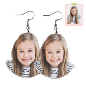 ES012jpg - printshop4me.ae Pair of custom photo drop earrings with silver hooks, each featuring a printed portrait of a smiling blonde girl in a striped shirt. The earrings are shaped like matching face cutouts, displayed on a clean white background with a small reference photo in the top right corner.