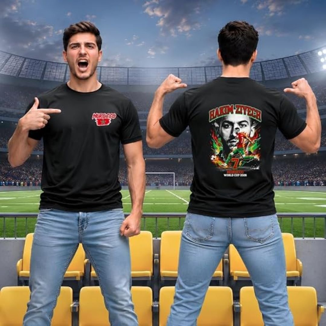 Morocco football men's black T-shirt worn in a stadium, featuring a small Morocco chest logo on the front and a large Hakim Ziyech number 7 World Cup 2026 inspired graphic on the back with Moroccan flag colors.