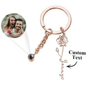 Personalized projection photo keychain in a rose gold finish, featuring a custom engraved rose with name charm and a hidden photo projection lens. Displayed with a sample projected couple photo, this elegant keychain makes a meaningful gift for anniversaries, Valentine's Day, birthdays, weddings, or special occasions.