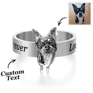 Silver custom dog ring featuring a raised 3D engraved dog face centerpiece, with engraved text around the band (“forever” and partial “Love”). Arrows indicate personalization areas, including custom text and a reference photo of a small black-and-white dog in the top right, showing the transformation from photo to engraved jewelry design.