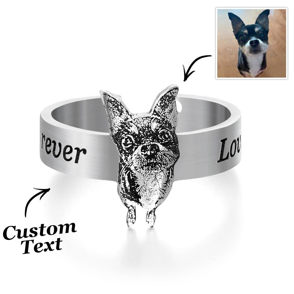TKR843jpg - printshop4me.ae Silver custom dog ring featuring a raised 3D engraved dog face centerpiece, with engraved text around the band (“forever” and partial “Love”). Arrows indicate personalization areas, including custom text and a reference photo of a small black-and-white dog in the top right, showing the transformation from photo to engraved jewelry design.