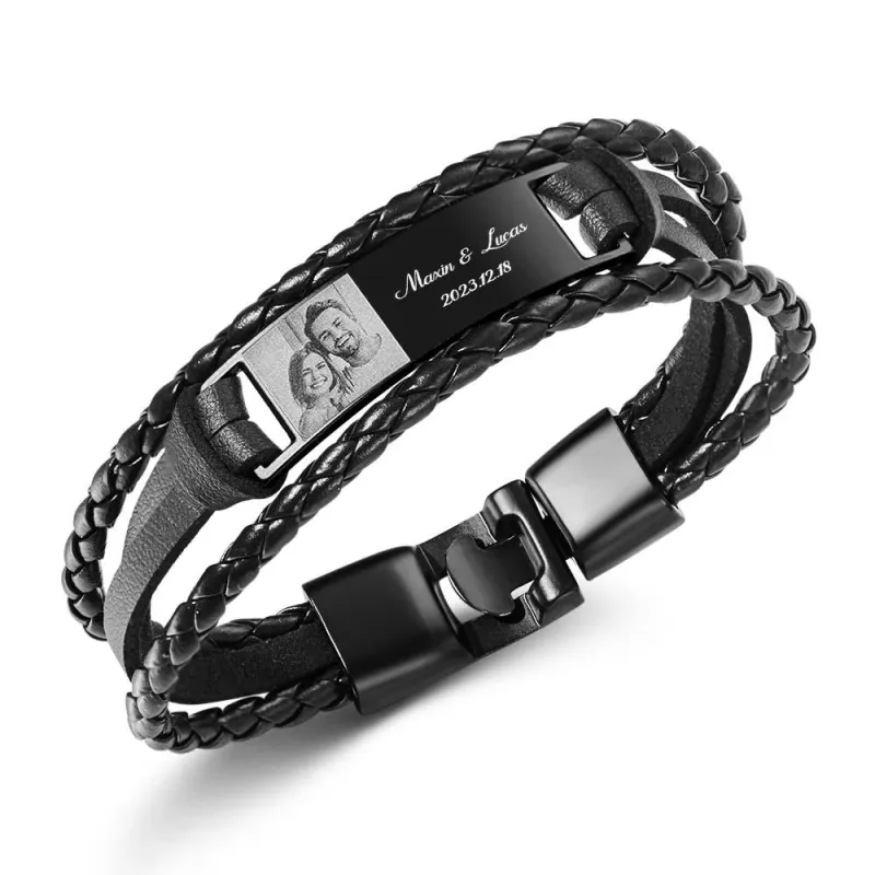 a194ab7e59c1b8d543fcea07681ddadfwebp - printshop4me.ae A personalized black braided leather bracelet featuring a metal nameplate engraved with “Maxim & Lucas” and the date “2023.12.18.” The bracelet also includes a small engraved photo panel of a couple, combining a custom photo and text design. The clasp is magnetic and the overall style is a modern men’s gift accessory.