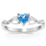 Elegant silver infinity heart ring featuring a sparkling blue heart-shaped birthstone at the center. The polished band is designed with graceful infinity symbols on both sides, symbolizing eternal love and commitment. This minimalist personalized birthstone ring is a meaningful gift for birthdays, anniversaries, Valentine's Day, engagements, Mother's Day, or everyday wear.