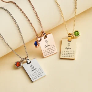 Set of personalized calendar pendant necklaces available in silver, rose gold, and gold finishes, each featuring a custom engraved name, special date calendar, delicate flower design, and birthstone charm. Elegant personalized necklaces displayed on matching chains, ideal for anniversaries, birthdays, Valentine's Day, Mother's Day, weddings, or meaningful keepsake gifts.