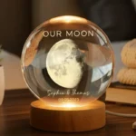 Personalized crystal moon lamp with engraved names and date, featuring a realistic moon inside a clear glass sphere on a wooden LED base. A romantic custom night light decoration for couples, anniversaries, weddings, and special gifts.