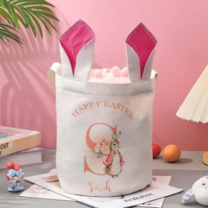 Personalized Easter bunny gift basket featuring a white fabric tote with bunny ear design, rabbit illustration, and custom name print. A festive Easter storage bag for holding eggs, candies, and small gifts, suitable for spring celebrations and holiday gifting.
